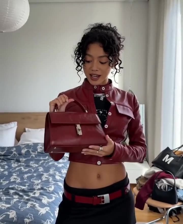 Fotogramma verticale di un contenuto fashion con borsa bordeaux.